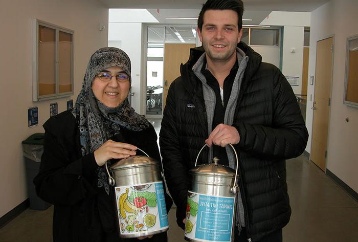 Senior Dakota Schoppe (left) and Dr. Mahsa Kazempour are pictured with the composting containers now found across campus. 