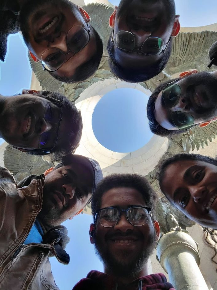 A group of students looking down at a camera in a circle