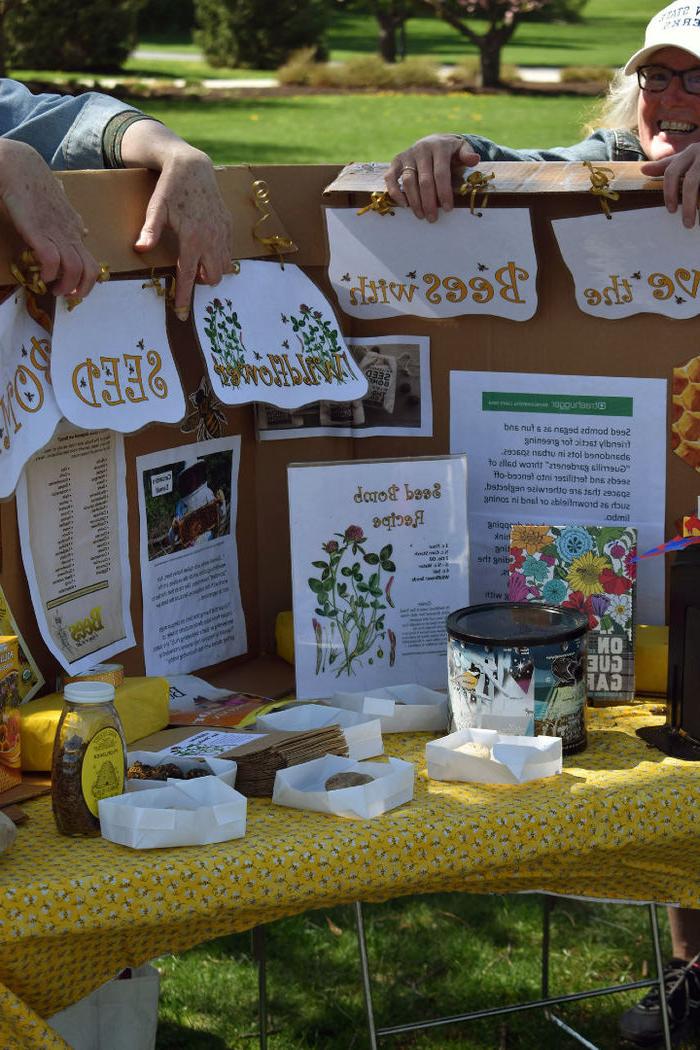 Students hold up an informational sign about bees' role in the ecosystem