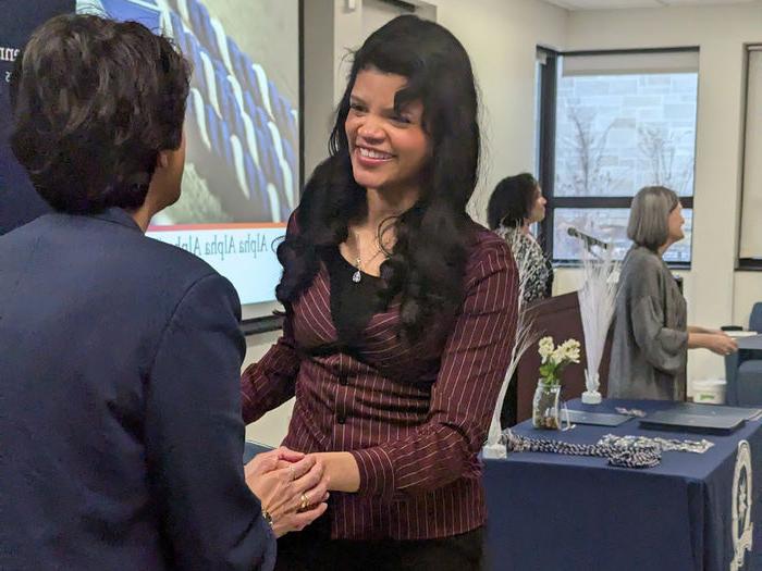 Smiling student shakes Chancellor's hand