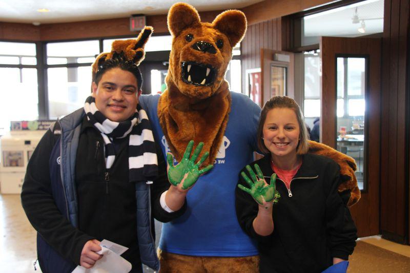 Students with their hands covered in green paint 