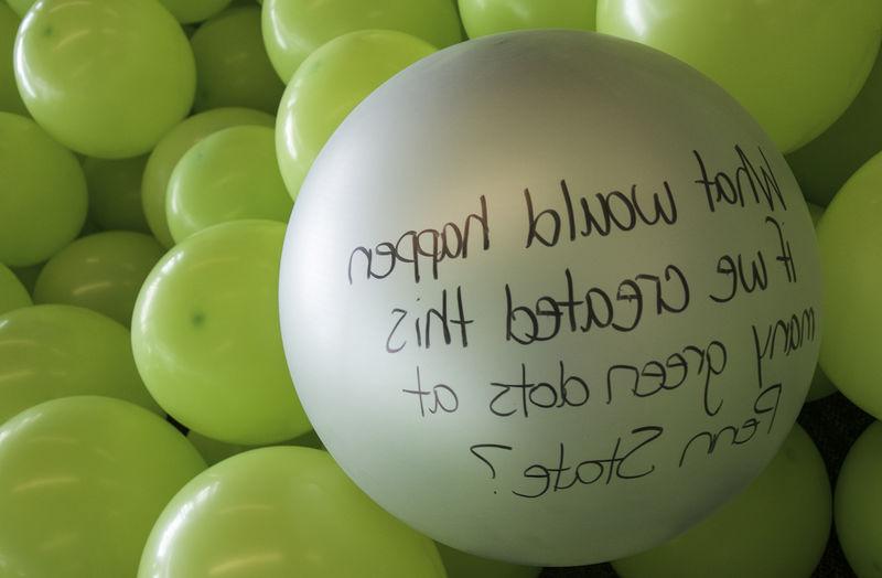 A balloon with the message "What would happen if we created this many green dots at Penn State?"