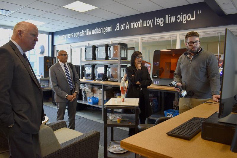 Instructor demonstrates something on computer screen for Bendapudi