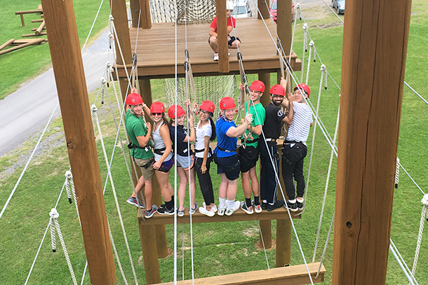 Students stand on a bridge as part of an obstacle course