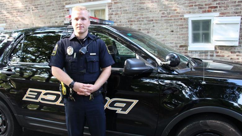 University Police Officer Luke Shivery next to patrol car