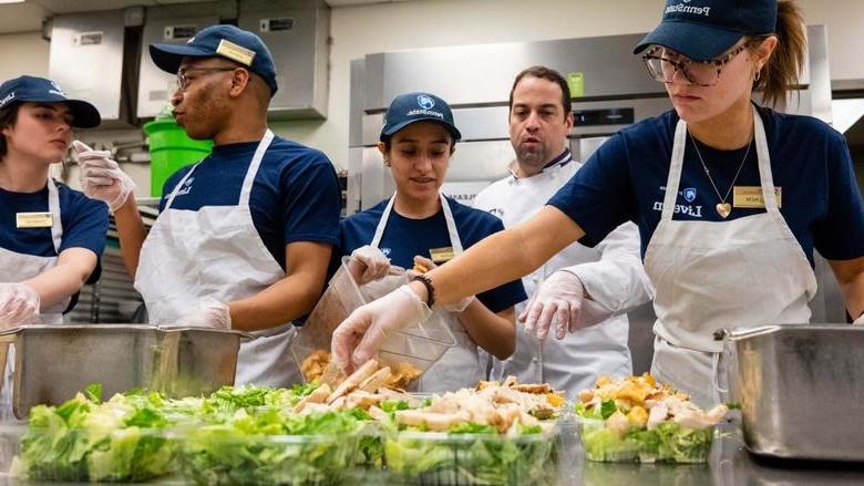 Berks students work in a food serve environment preparing salads as part of a hospitality management course