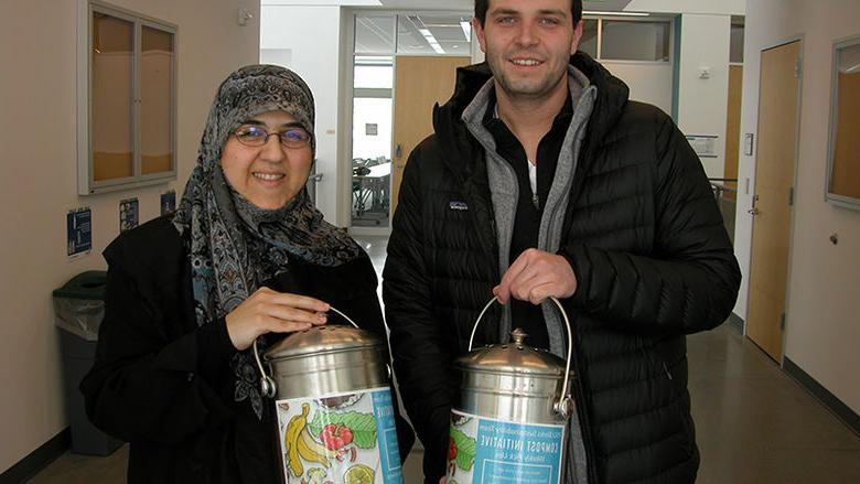 Senior Dakota Schoppe (left) and Dr. Mahsa Kazempour are pictured with the composting containers now found across campus. 