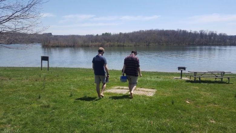 Two people facing out looking at a lake