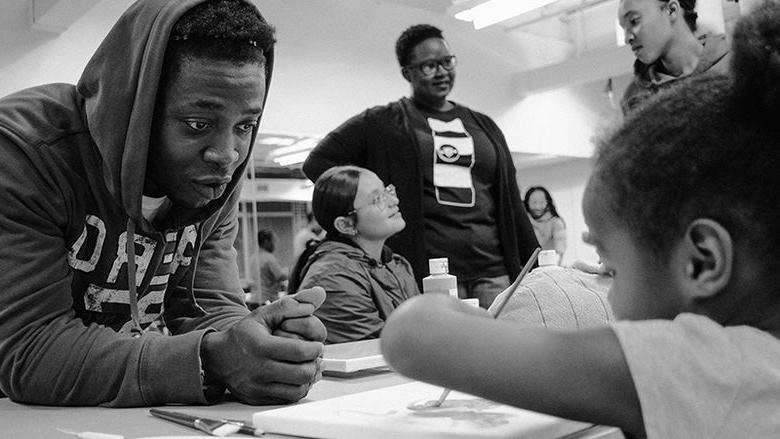 Criminal Justice Students works with youth on painting skills.
