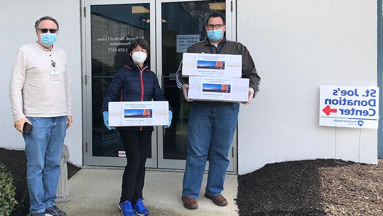 Red Yuan, helps deliver a donation of 1,500 surgical masks.