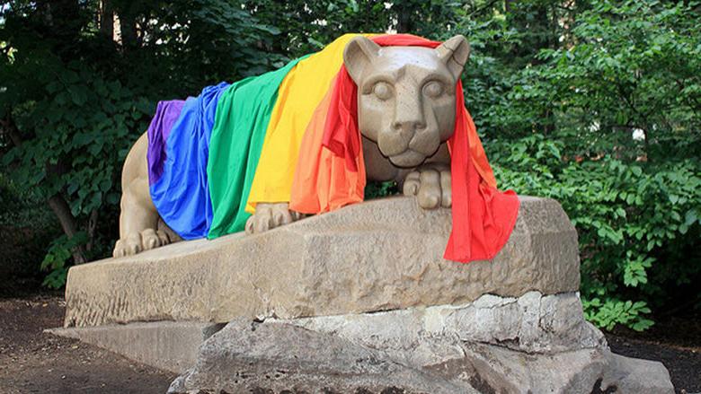 A rainbow pride flag draped over the Nittany Lion.