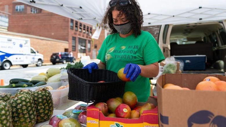 Christina Houston, a staff member of Blue Mountain Academy, arranges produce to be sold at the farm stand at Penn State Health St. Joseph Downtown Campus.