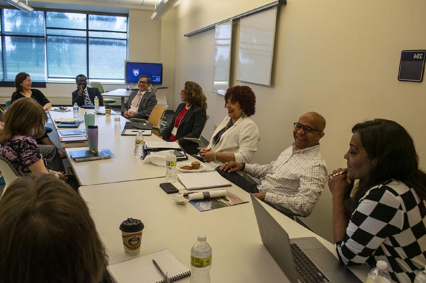 A team from Penn State Harrisburg talks while sitting around a large conference table