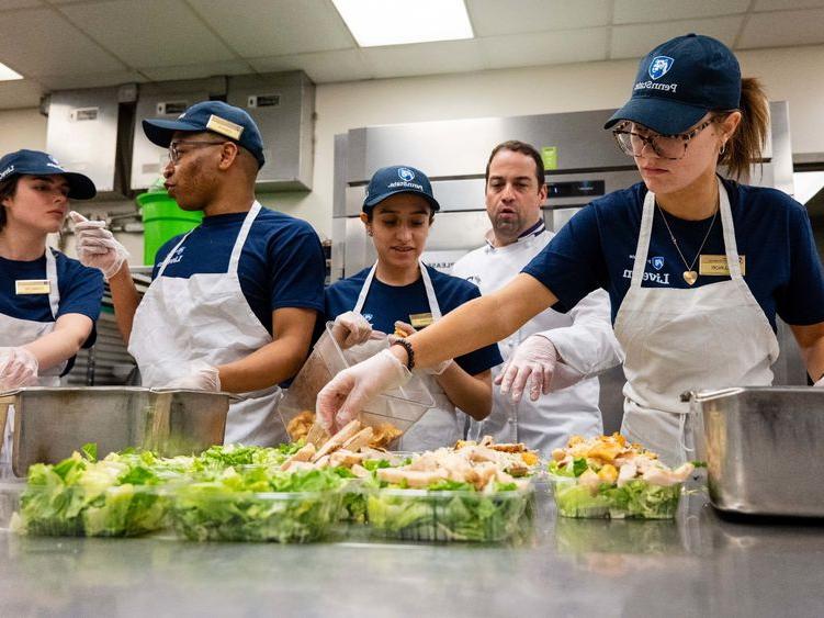 Berks students work in a food serve environment preparing salads as part of a hospitality management course