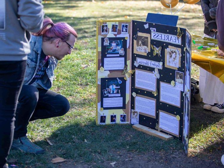 Community member reading student's research poster
