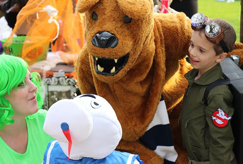 Trick-or-Treaters getting their photo taken with the lion at Fall Fest.