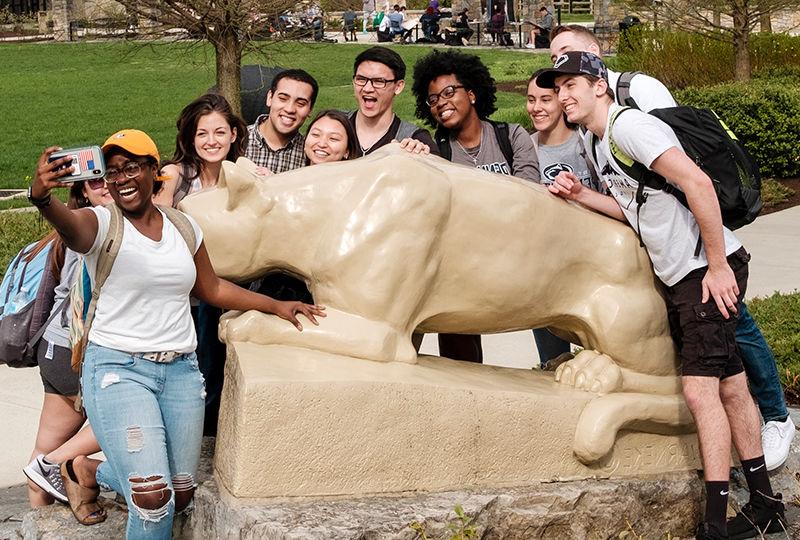 Students taking a selfie in front of the lion shrine.