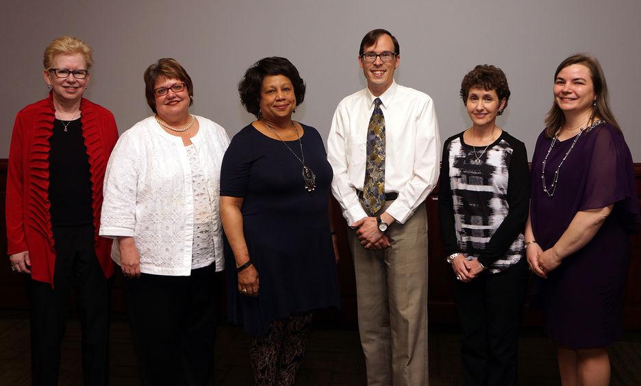 group of five women and one man standing in a row after being honored at a ceremony