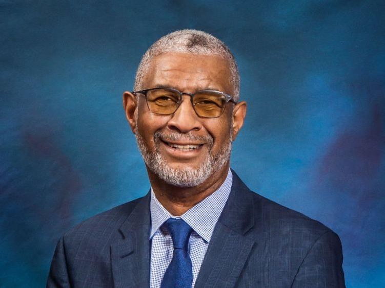 A headshot of Penn State Berks Chancellor George Grant Jr. wearing a blue suit against a blue background.
