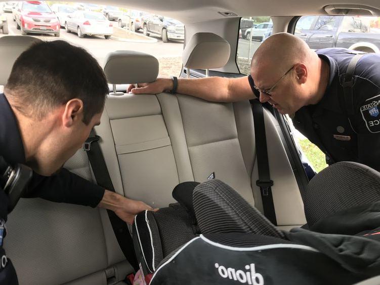 officers inspect child safety seat