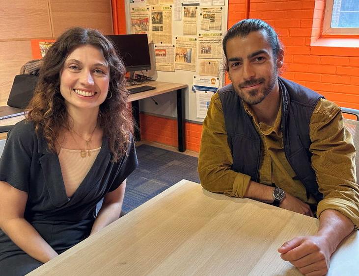 Two people sitting at a table and facing the camera