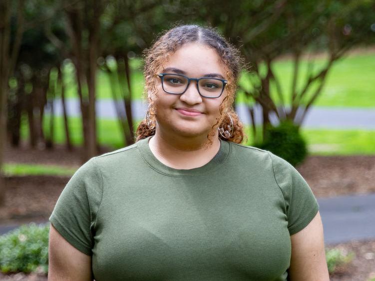 Student soloist Malinda Garcia wearing olive green t-shirt.